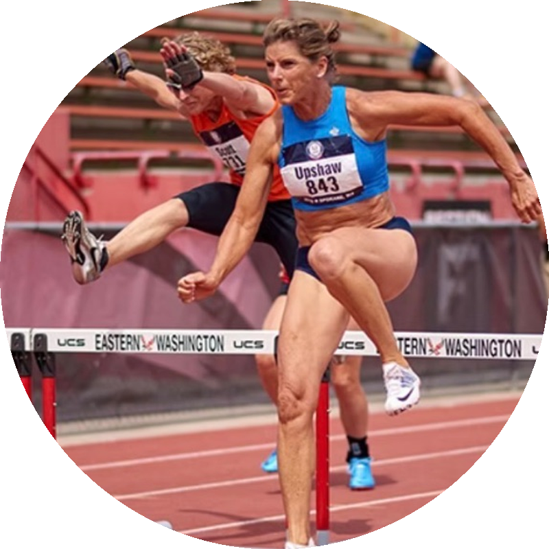 Joy Upshaw clearing a hurdle in competition